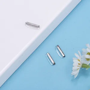 Makro-Detail von 10 mm Silberzylinder-Metallteilen in klaren Kapseln für DIY-Schmuckstücke