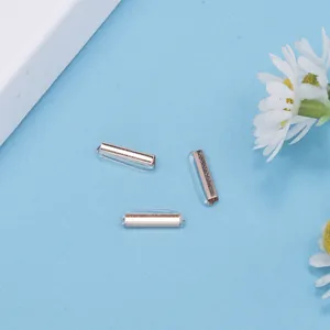 Detailansicht von drei roségoldenen Metallverbindern mit Silikon-Sicherheitshüllen