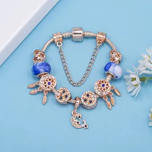 Pulsera de dijes en oro rosa con colgantes de atrapasueños y luna con estrellas