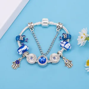 Silver evil eye charm bracelet with blue crystal, glass beads and Hamsa hand pendants