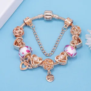 Roségoldenes Schlangenarmband mit rosa Glasperlen und Herzanhängern für Damen auf Blau