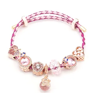 Rosa geflochtenes Lederarmband mit Roségold-Herzanhängern und floralen Elementen