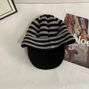 Detailed view of striped knit visor beanie in black and grey with warm thick texture