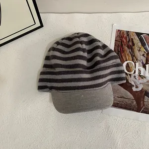 Detail of grey and black striped knitted visor beanie on a stylish magazine background