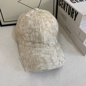 Detailed close-up of distressed vintage baseball cap with ripped denim texture and washed effect