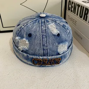 Close-up of vintage blue denim docker hat with CREATE embroidery and distressed details
