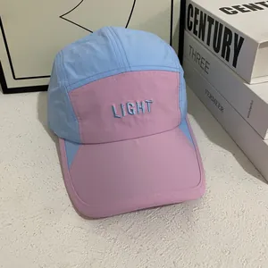 Detail of five-panel baseball cap showing pink and light blue color block with LIGHT embroidery