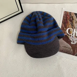 Detailed knit texture of the blue and grey striped knitted beanie with a short brim