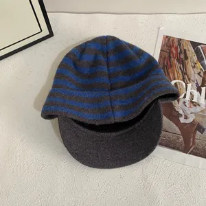 Detailed close-up of blue and grey striped knit baseball cap with soft texture