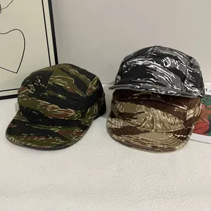 Gros plan de trois casquettes de camping camouflage à rayures de tigre vintage
