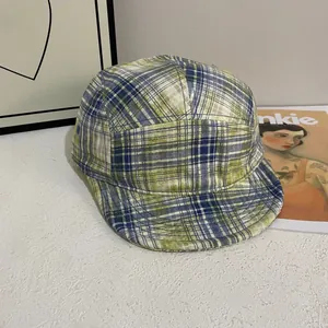 Detail einer Vintage Five-Panel Camper-Mütze mit grünem Karo und Metallösen