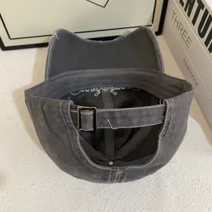 Detail of vintage washed gray baseball cap with adjustable strap and metal buckle