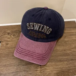 Detail der SEWING-Stickerei auf einer dunkelblau-roten Vintage-Baumwollkappe
