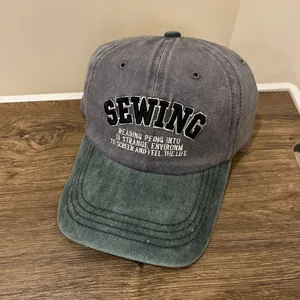 Detail der Vintage-Baseballkappe mit grau-grünem Kontrast und SEWING-Stickerei