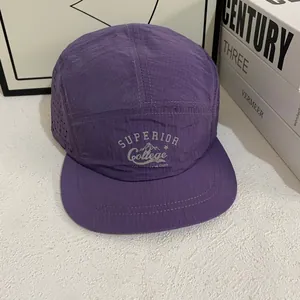 Detail of purple camp cap with laser-cut side vents and superior college mountain print