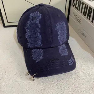 Distressed navy blue cotton baseball cap with metal rings and Courage embroidery detail
