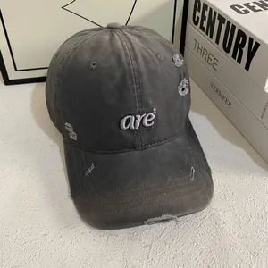 Close-up of distressed washed grey canvas baseball cap with white are² embroidery