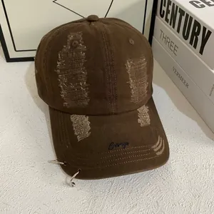 Detail of distressed cotton baseball cap with Courage embroidery and silver rings