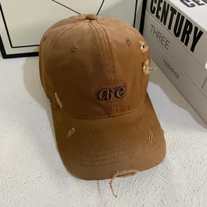 Detailed view of brown distressed baseball cap with embroidery and frayed edges