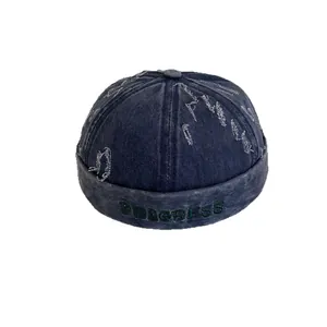 Distressed navy denim melon cap with PROGRESS embroidery and vintage frayed edges