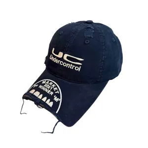 Close-up of distressed navy blue cotton baseball cap with white UC Undercontrol embroidery