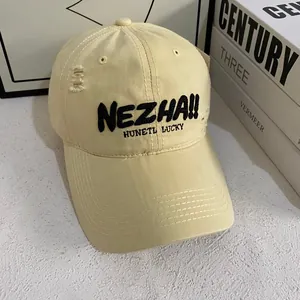 Detail view of embroidered lettering and distressed fabric on a yellow baseball cap