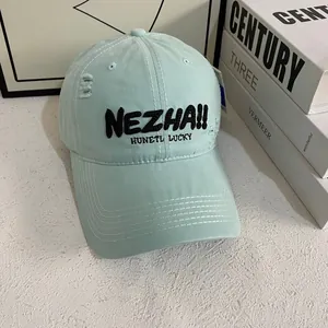 Detail of light blue baseball cap with black 3D embroidery and distressed ripped effects