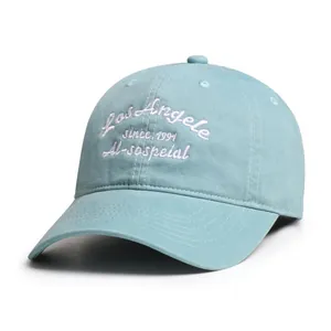 Detalle de gorra de béisbol de algodón azul claro con bordado blanco y tejido fino