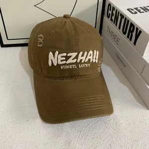 Close-up of distressed vintage brown baseball cap with white 3D NEZHA embroidery