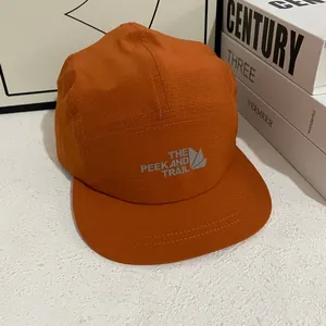 Detalle de gorra camping de 5 paneles naranja en tejido de secado rápido con logo