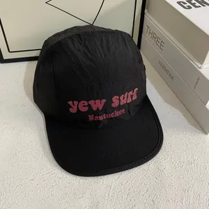 Detail van de zwarte 5-panel campingpet met paarse yew surf print sneldrogend