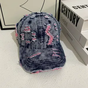 Close-up of distressed vintage denim baseball cap showing pink frayed fabric details