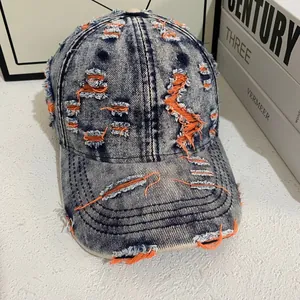 Close-up of distressed vintage denim baseball cap with orange fabric inner lining detail