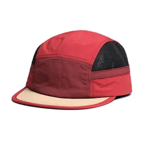 Detail van de five-panel pet met rode patchwork en ademend zwart mesh materiaal