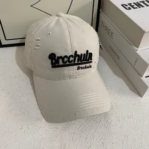 Dettaglio ravvicinato di cappello beige con ricamo 3D e rifiniture consumate moda