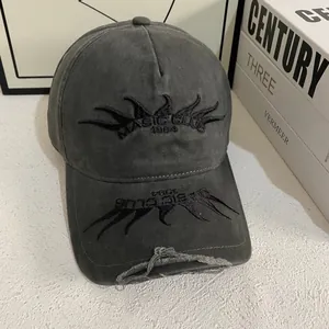 Detailed view of black flame embroidery and distressed edges on a vintage baseball cap