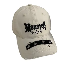 Beige baseball cap with Monster embroidery, metal rivets and street style punk aesthetics