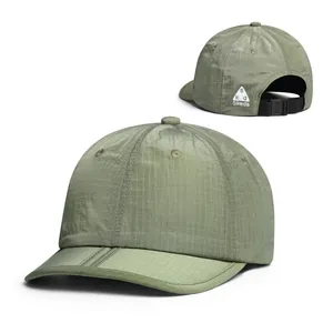 Detail view of olive green ripstop fabric and adjustable buckle on a foldable baseball cap