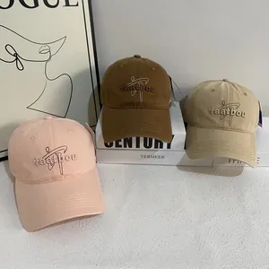 Three embroidered cotton baseball caps in pink, brown, and khaki for casual styling