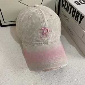 Detailed close-up of pink 3D letter D embroidery on vintage beige washed canvas baseball cap