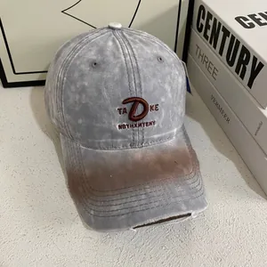 Close-up of vintage washed grey cotton fabric with red 3D TAΚE embroidery on baseball cap