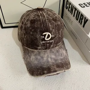Detail of vintage washed coffee baseball cap with white embroidery and distressed brim