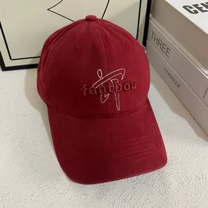 Detail of burgundy baseball cap with white abstract embroidery and faatbou lettering