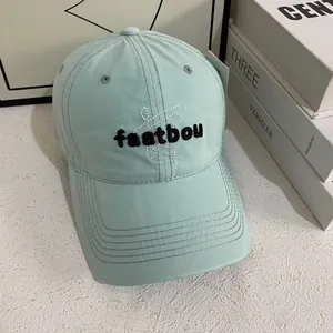 Mint green embroidered baseball cap with faatbou lettering in a stylish minimalist setting