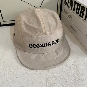 Dettaglio del cappellino beige a 5 pannelli in nylon ripstop con logo stampato ocean&sen