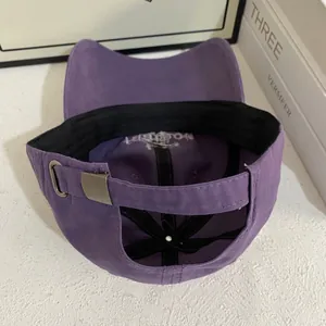 Detail view of purple cotton baseball cap showing adjustable metal buckle and inner sweatband
