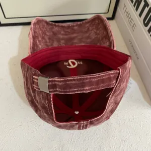Detail view of burgundy washed cotton baseball cap with adjustable silver metal buckle