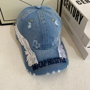 Vintage washed blue denim baseball cap with white wing embroidery and distressed details