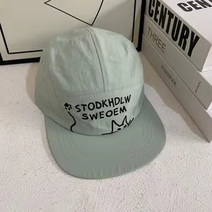 Detail of light green 5-panel camp hat with black cat embroidery and stitched flat brim