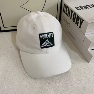 Dettaglio del berretto da baseball bianco in cotone con logo montagna ricamato su toppa
